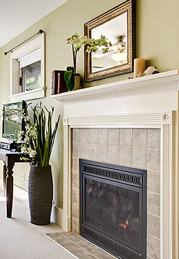 Fireplace with white mantel and beige walls behind it. 