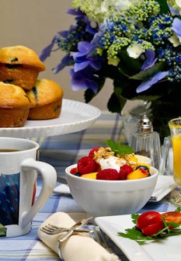 Breakfast table with fruit, muffins, coffee and orange juice.