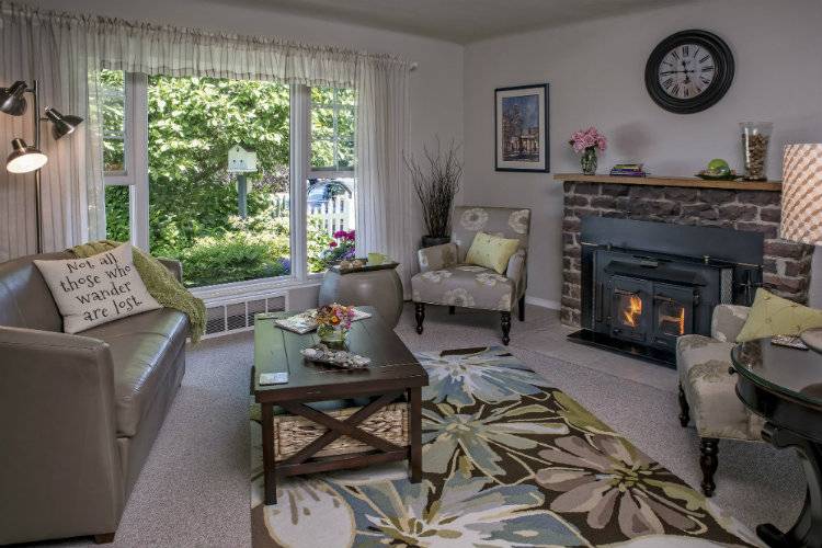 A sitting room at the Guest House B&B with dark gray furniture and light gray walls and carpet.