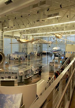 Plane display at a museum, several different planes, mostly white and blue.