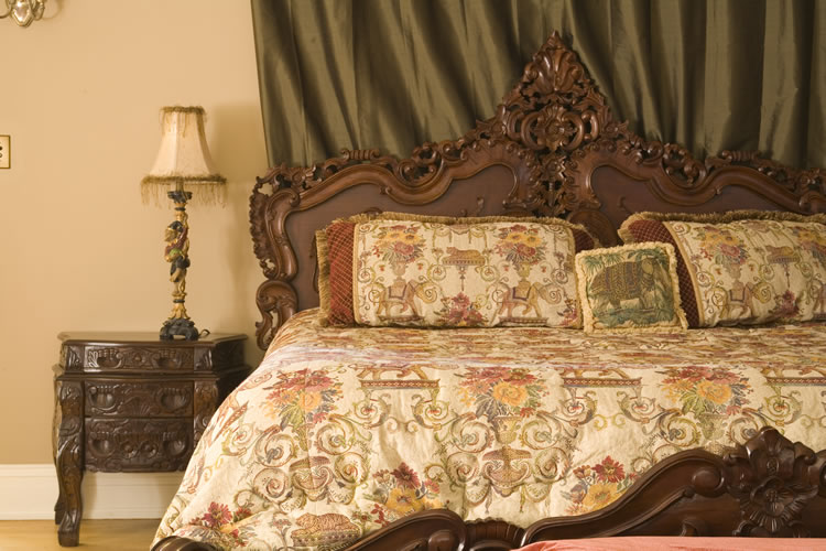 A bed on a brown wooden headboard, green curtains, and beige walls at the Shafer Baillie Mansion.A bed on a brown wooden headboard, green curtains, and beige walls at the Shafer Baillie Mansion.