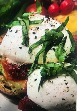 Eggs Benedict on toasted muffin with cherry tomatoes